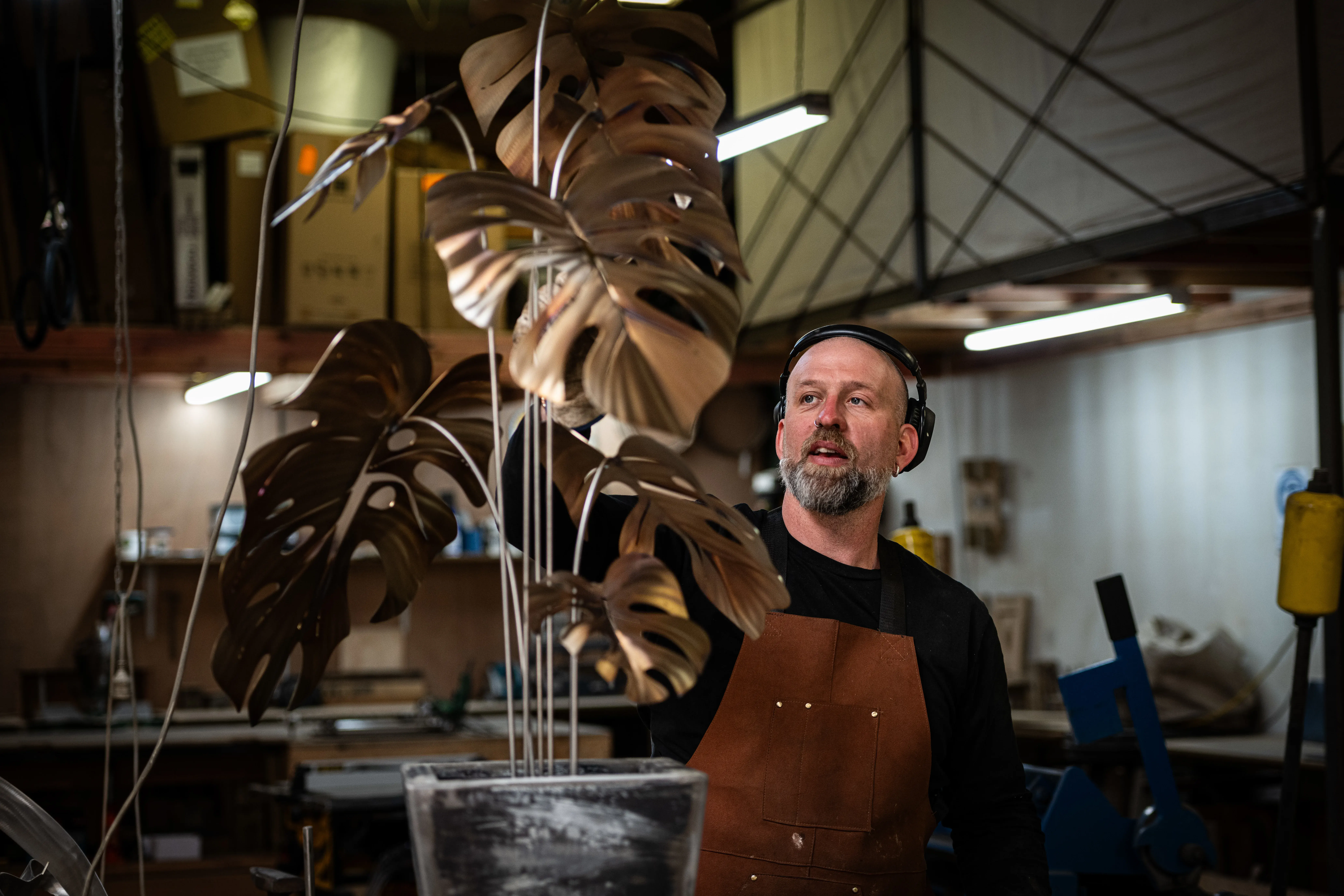 Artist with completed monstera sculpture
